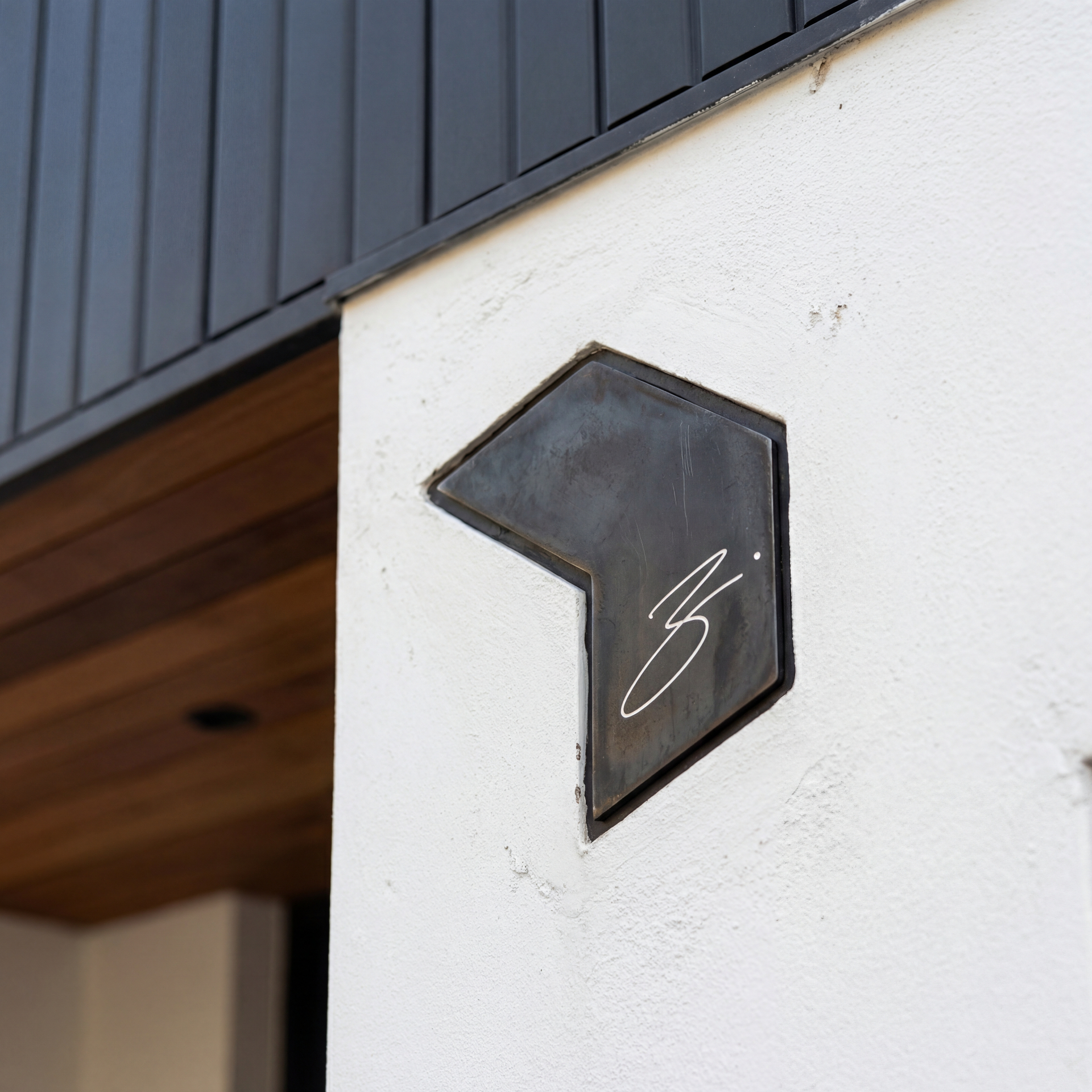 Blocharch architectural signature mark mounted on a white facade